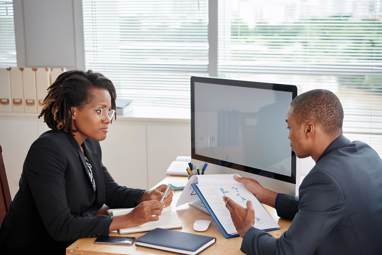 afro american man suit holding documents talking female boss (1) (1)